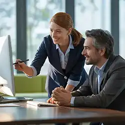 IT professionals reviewing security data on a computer monitor.